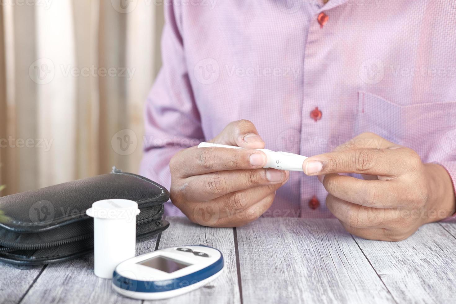 Man's hand measuring blood sugar level photo