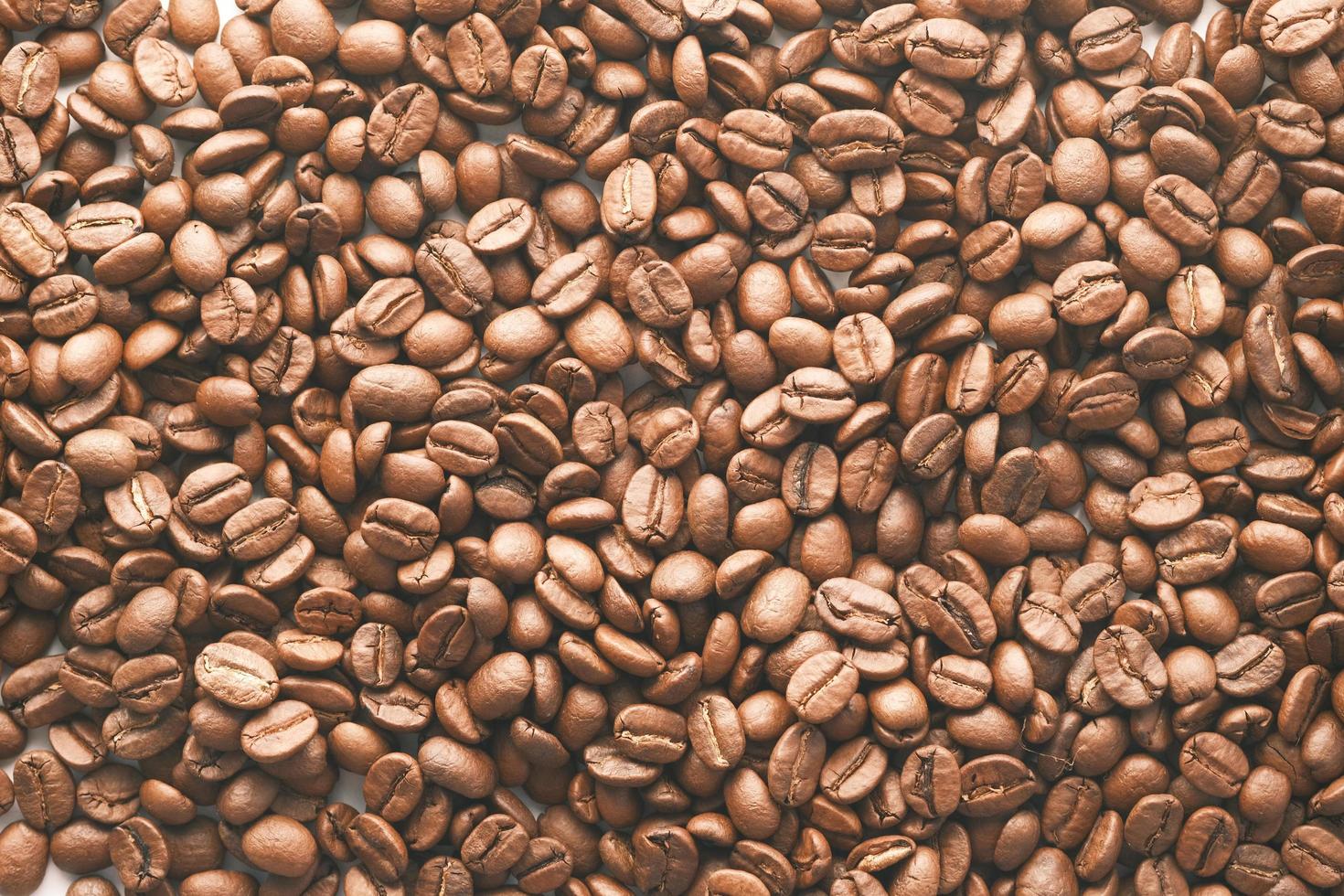 Vista superior de los granos de café frescos sobre fondo negro foto
