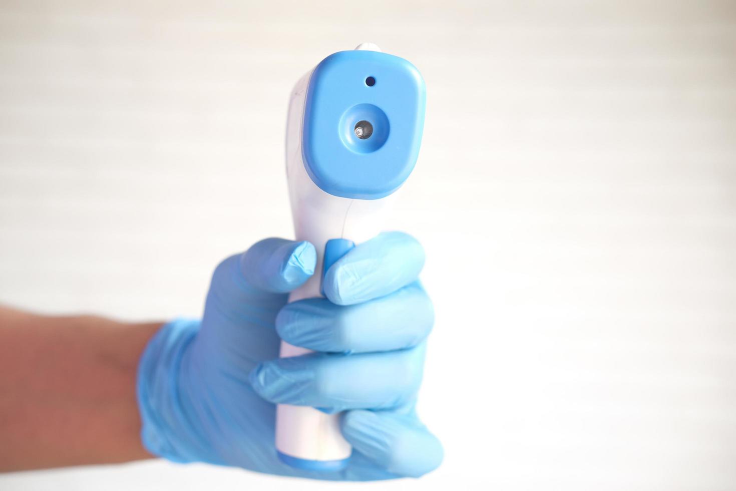 Hand holding infrared thermometer to measuring temperature. photo