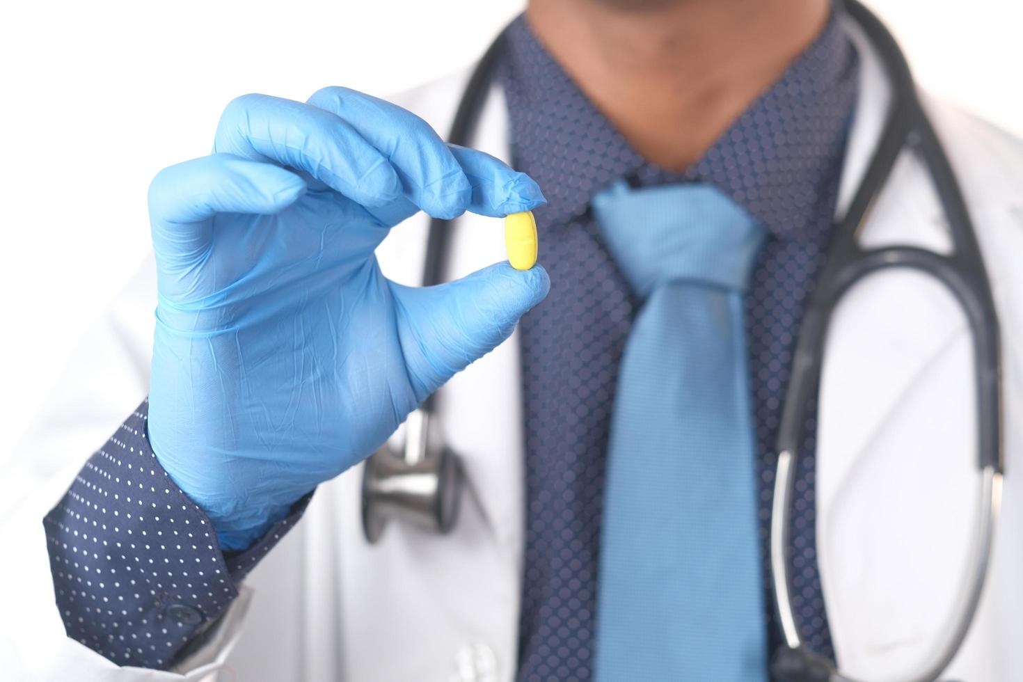 Doctor hand in protective gloves holding medical pills photo