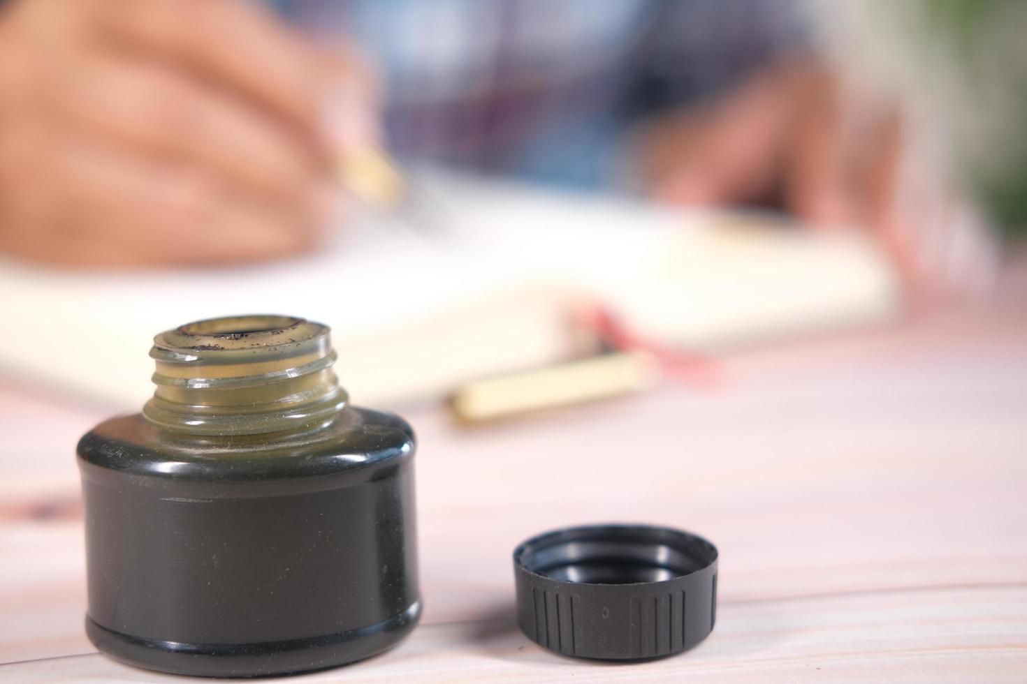 Ink, paper and fountain pen on table photo