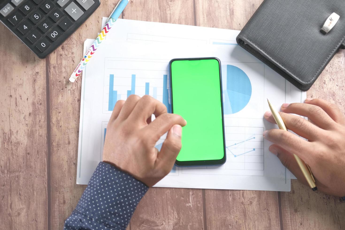 Top view of man hand using smart phone on office desk photo