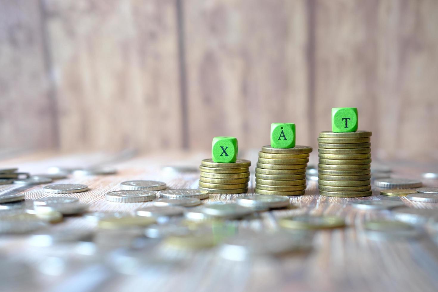 Bloque de madera con una palabra de impuestos sobre la pila de monedas foto