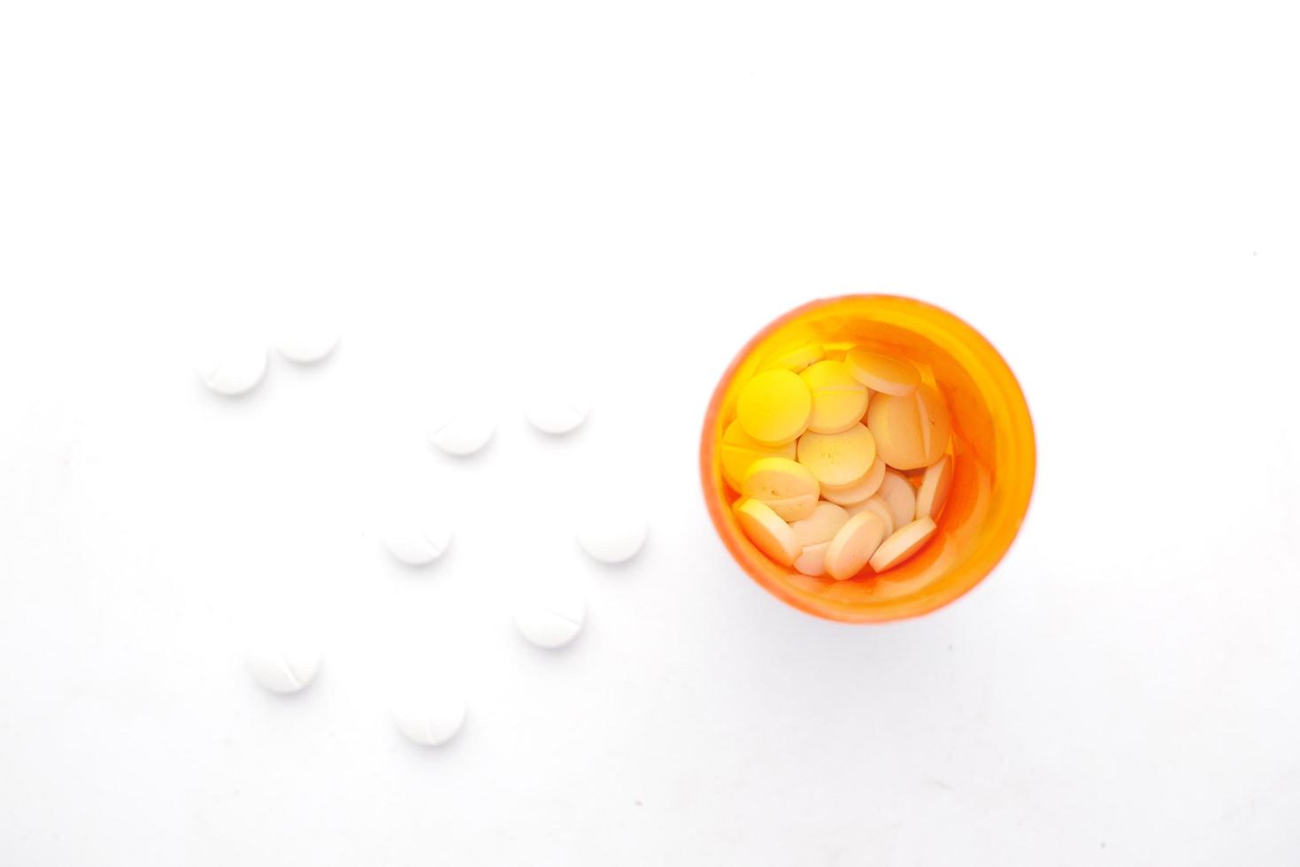 Close up of white pills spilling on white background photo