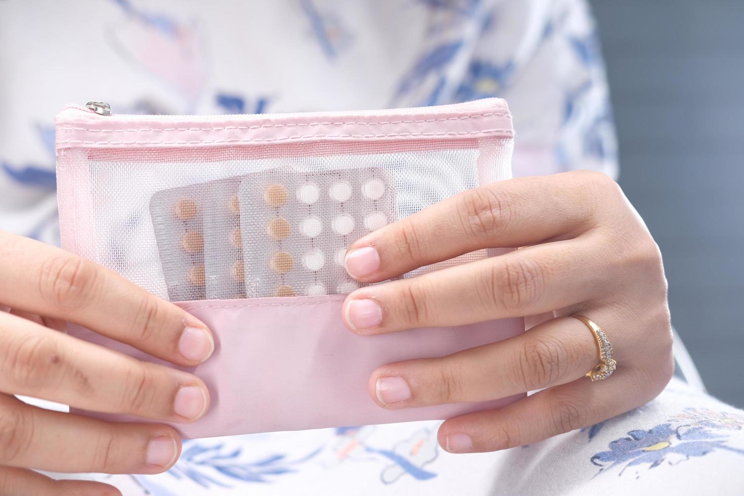 Women hand golding birth control pills close up photo