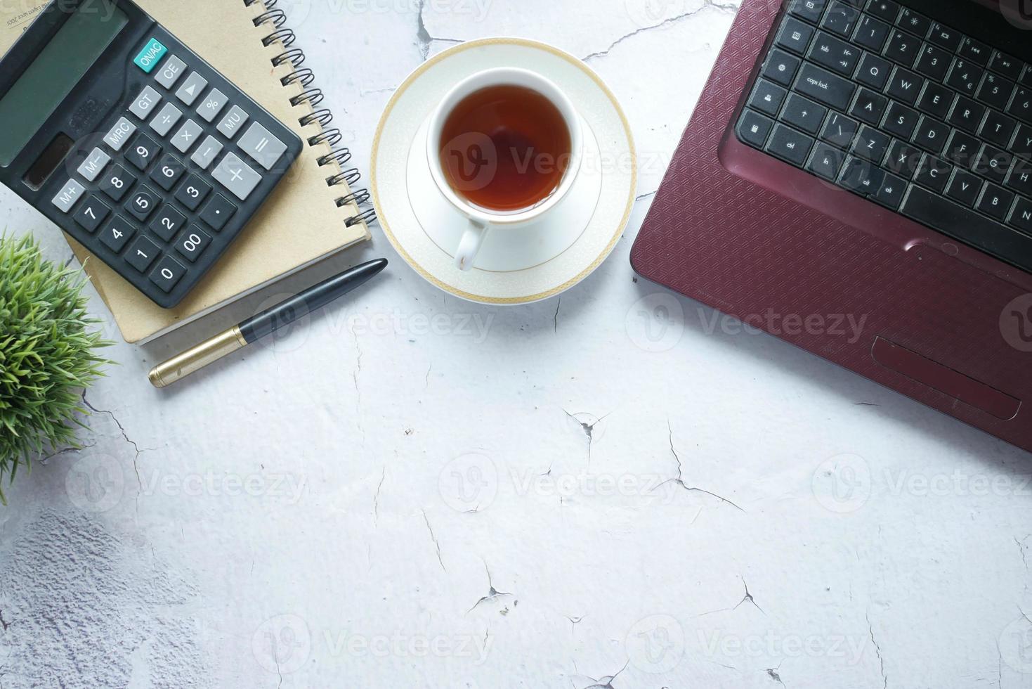 Flat composition of laptop and office stationary on white desk photo