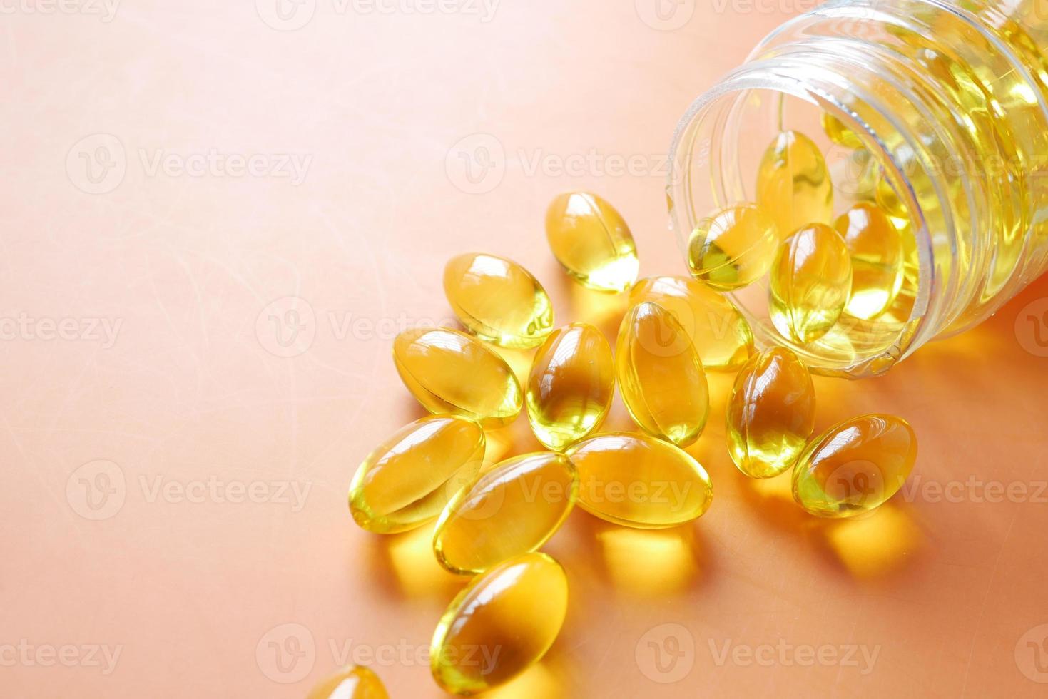 Close up of many vitamin capsule on orange background photo