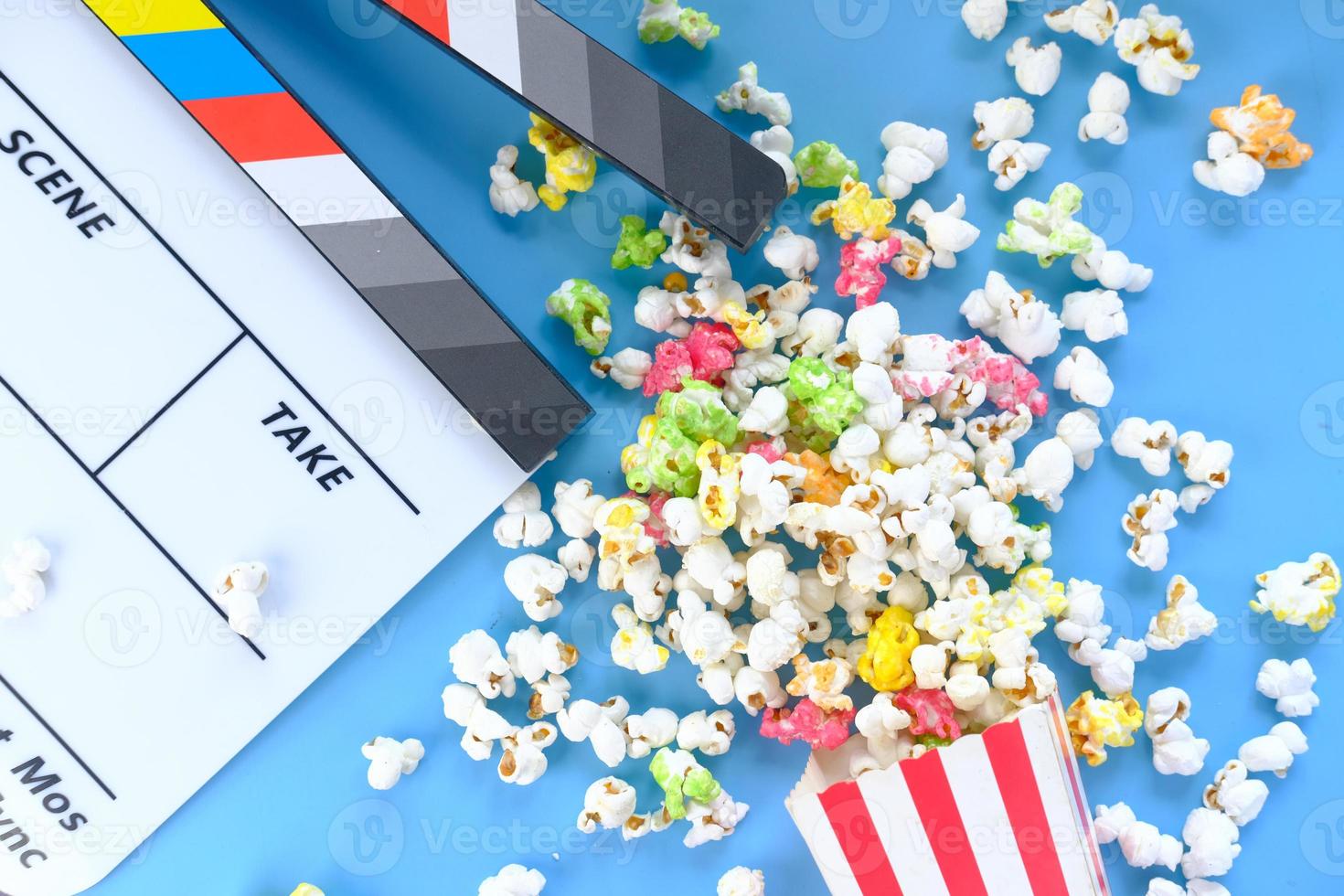 Movie clapper board and popcorn on blue background photo