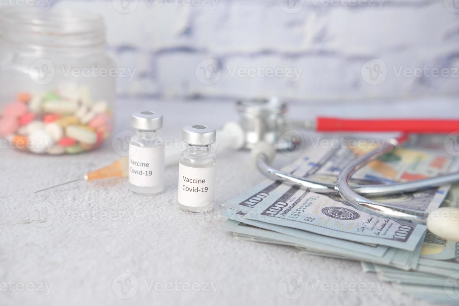 concepto de costo de atención médica con dólares estadounidenses, vacunas y píldoras foto