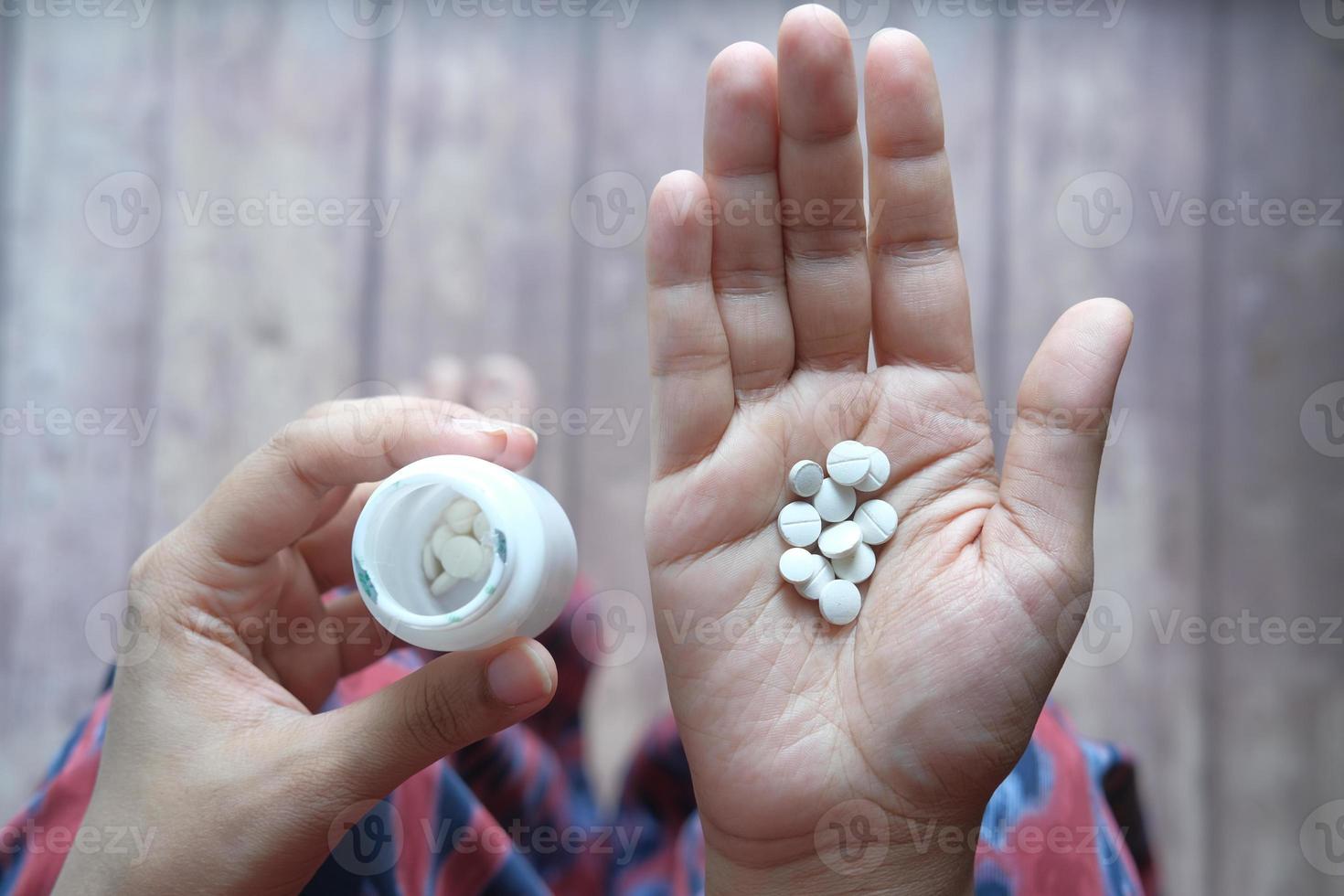 Cerca de la mano de la mujer tomando pastillas foto