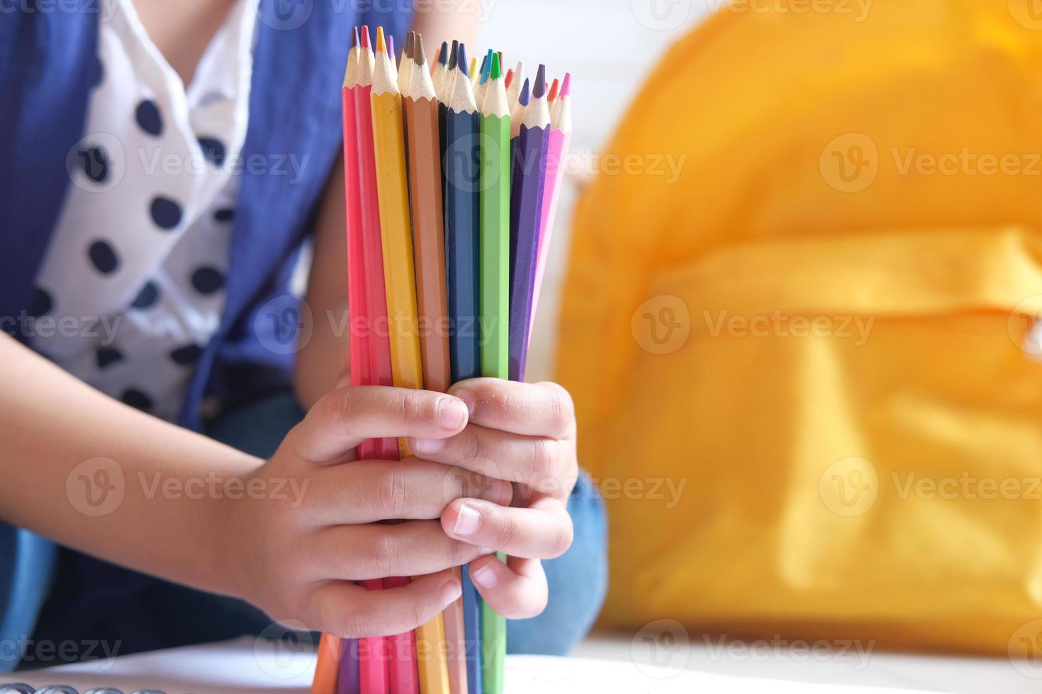 Child girl holding many color pencils photo