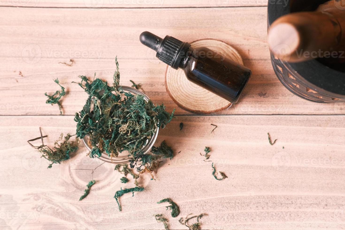 Eucalyptus essential oils in a glass bottle with green leaf on table photo