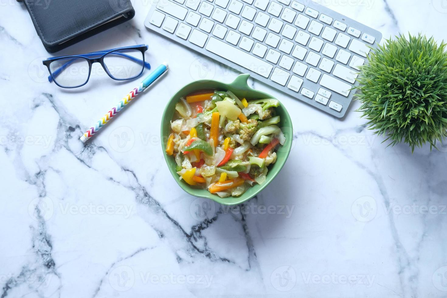 Vista superior del plato de verduras frescas hervidas en el escritorio de oficina foto