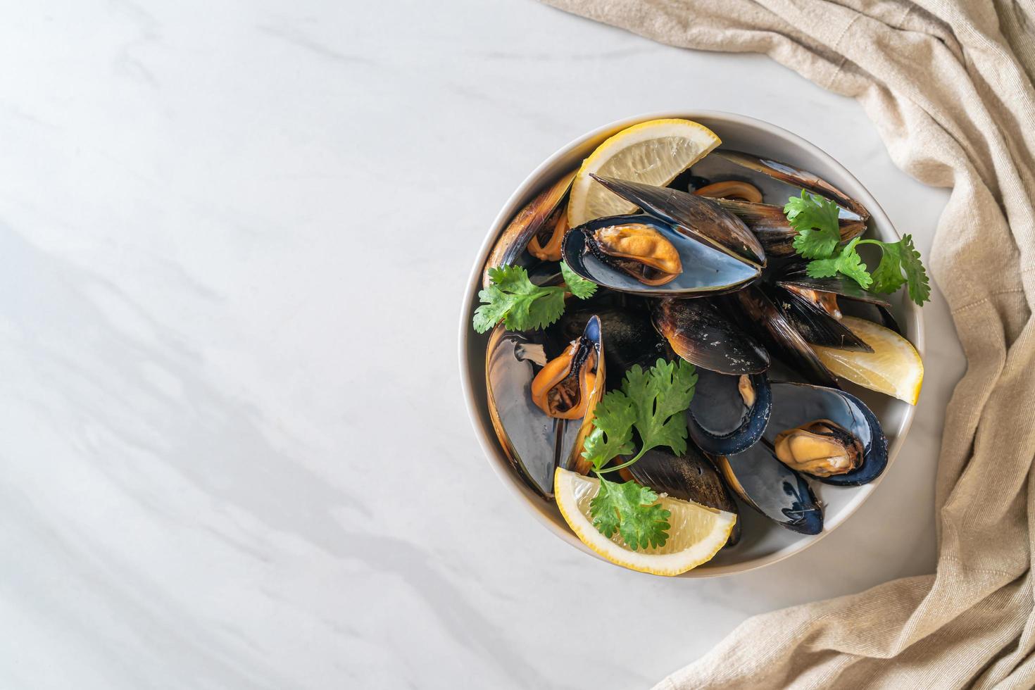 mejillones con hierbas en un bol con limón foto