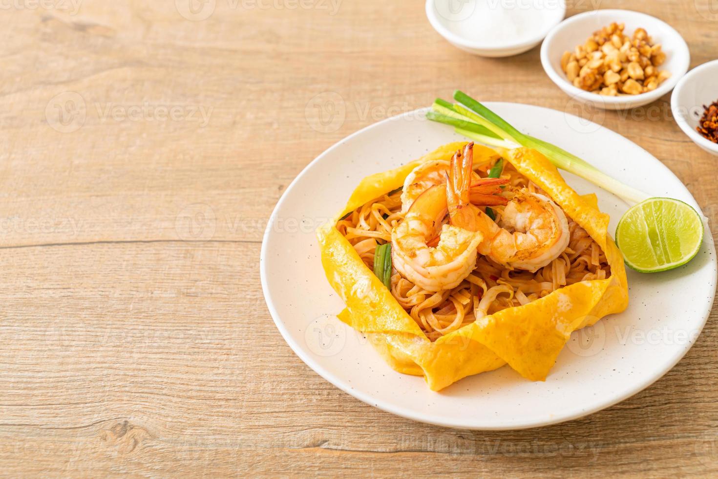 Thai stir fried noodles with shrimps and egg wrap photo