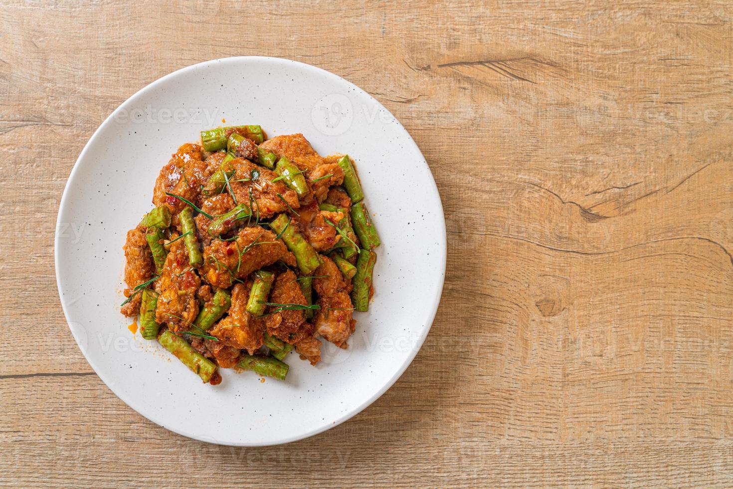 salteado de cerdo frito y pasta de curry rojo con frijoles picantes foto