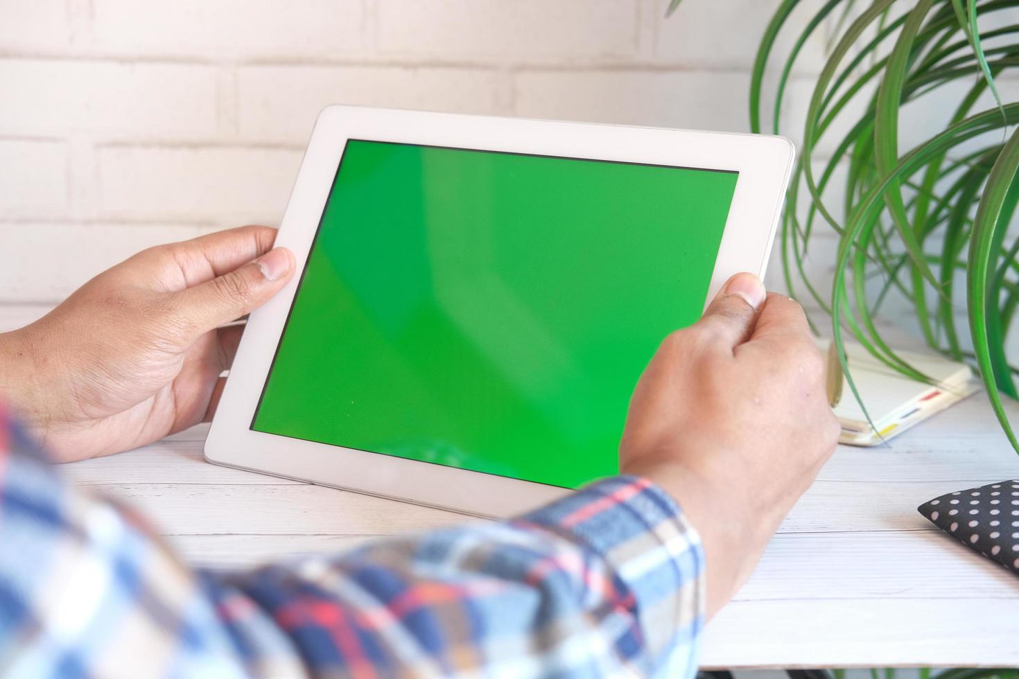 Rear view of young man suing digital tablet on office desk photo