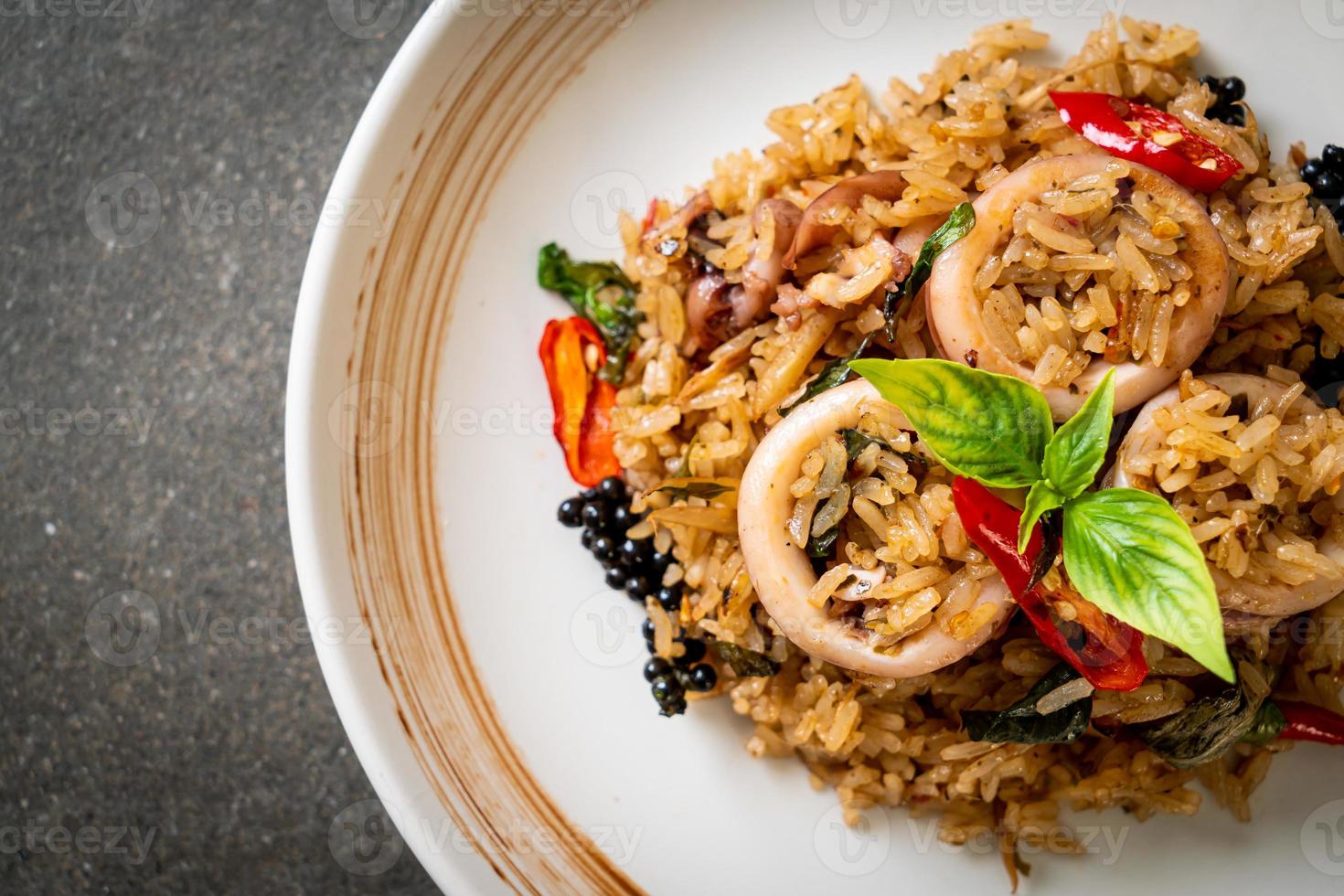 Arroz frito con albahaca y hierbas picantes con calamar o pulpo foto