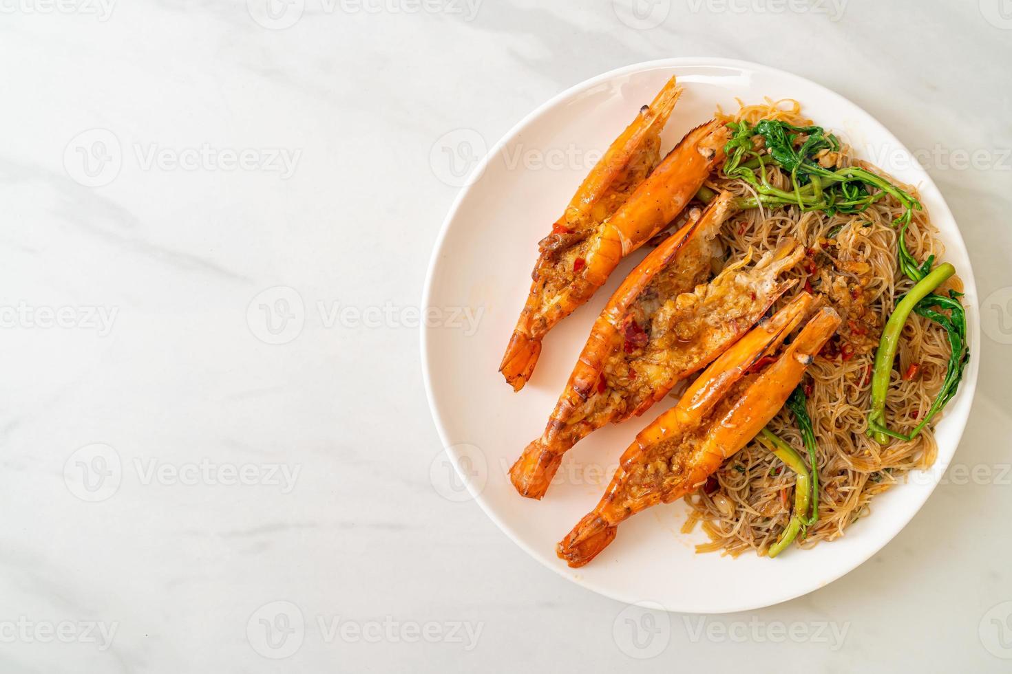 Fideos de arroz salteados y mimosa de agua con gambas de río foto