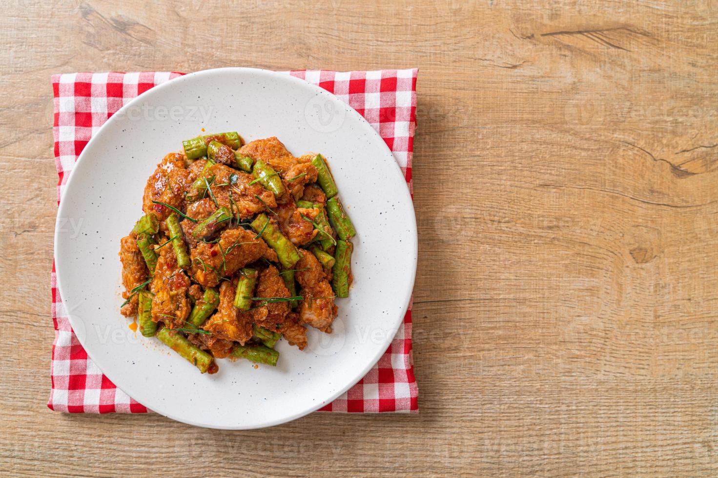 Stir fried pork and red curry paste with sting bean photo