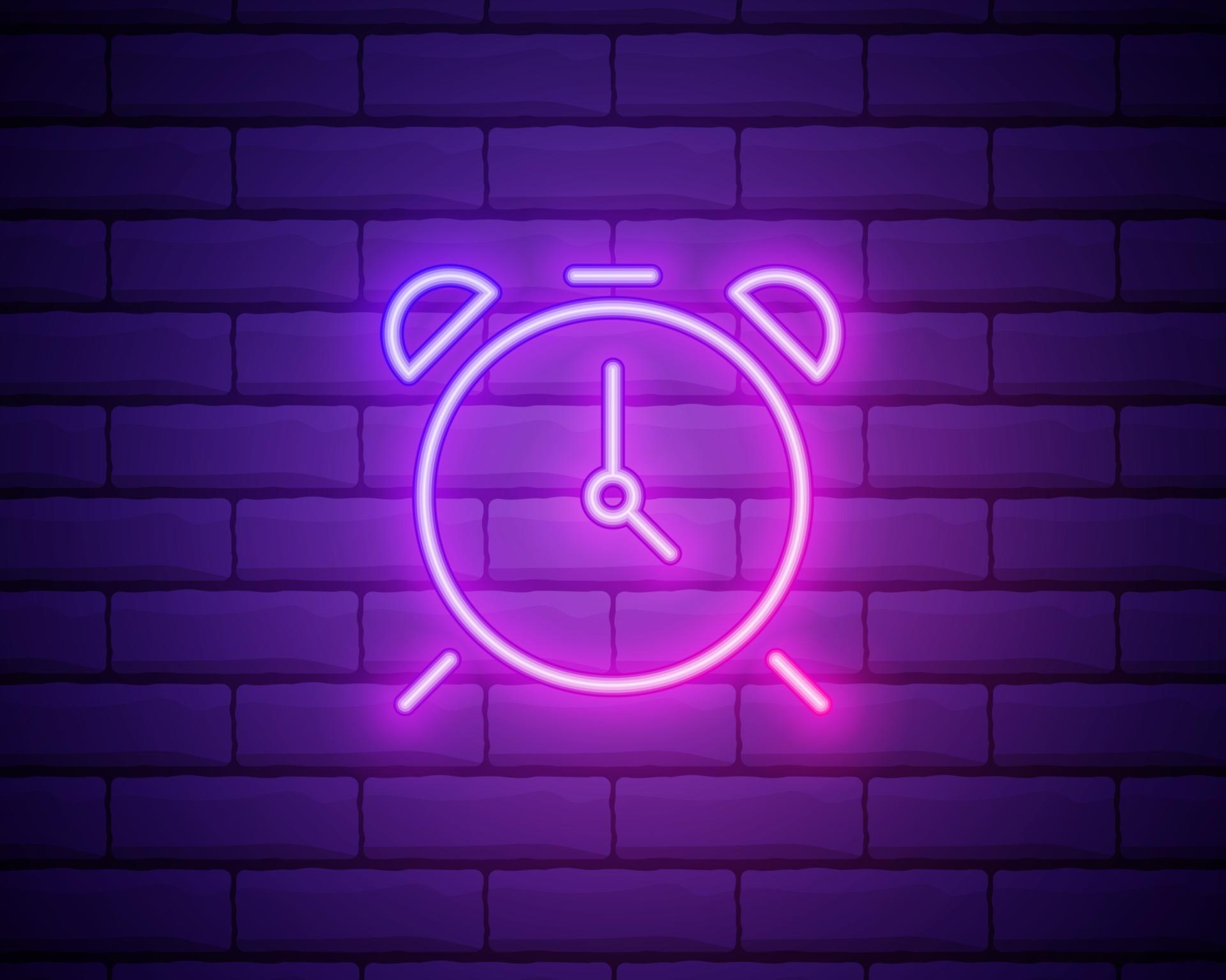 Glowing neon line Alarm clock icon isolated on brick wall background
