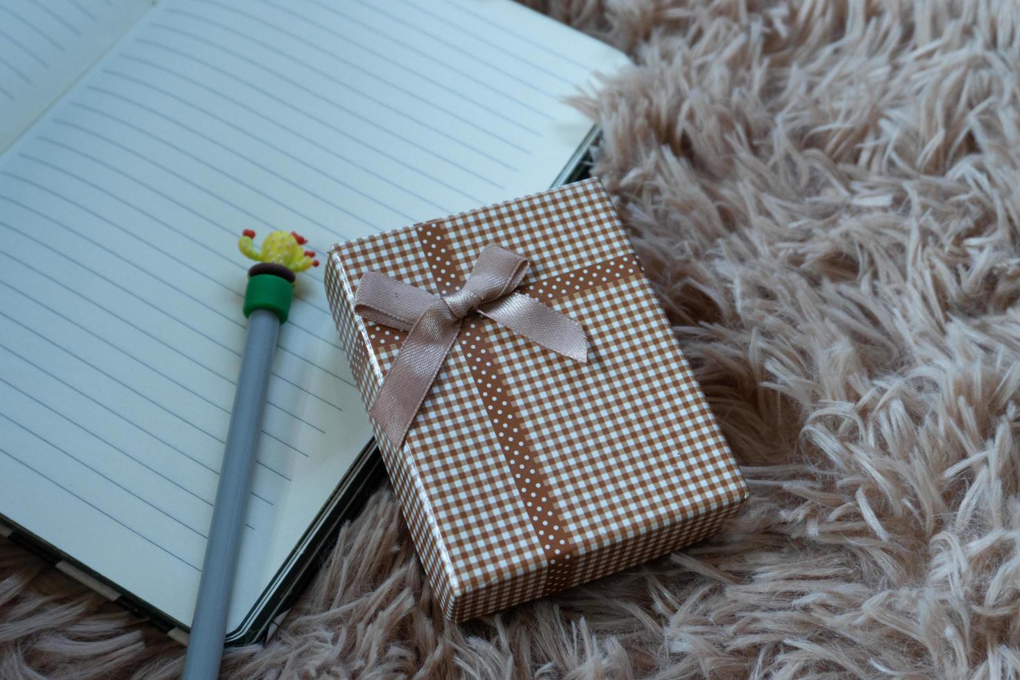 Gift box with a  ribbon and a Brown bow on a Wool carpet background. Selective focus. photo