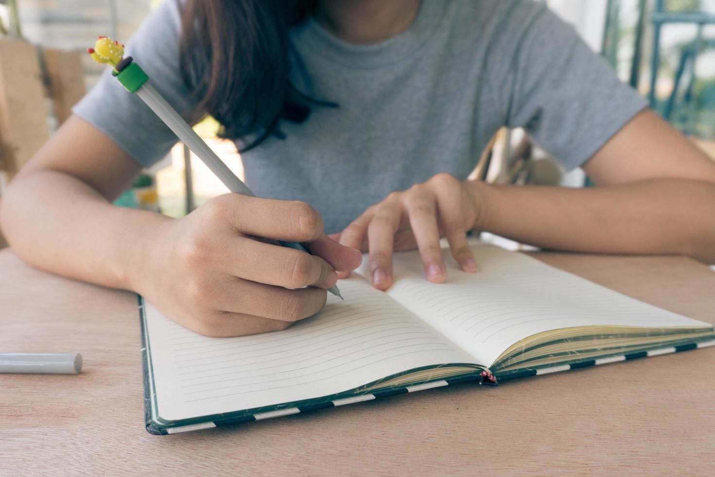 Vista cercana de una mujer estudiando en la mesa de madera foto