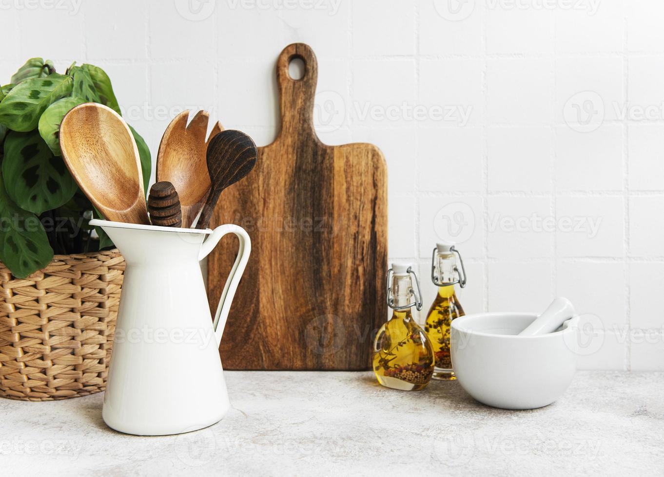 Kitchen utensils, tools and dishware on on the background white tile wall. photo