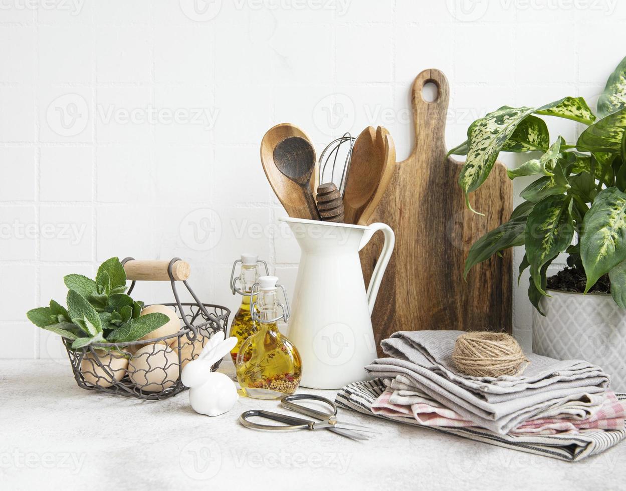 Kitchen utensils, tools and dishware on on the background white tile wall. photo