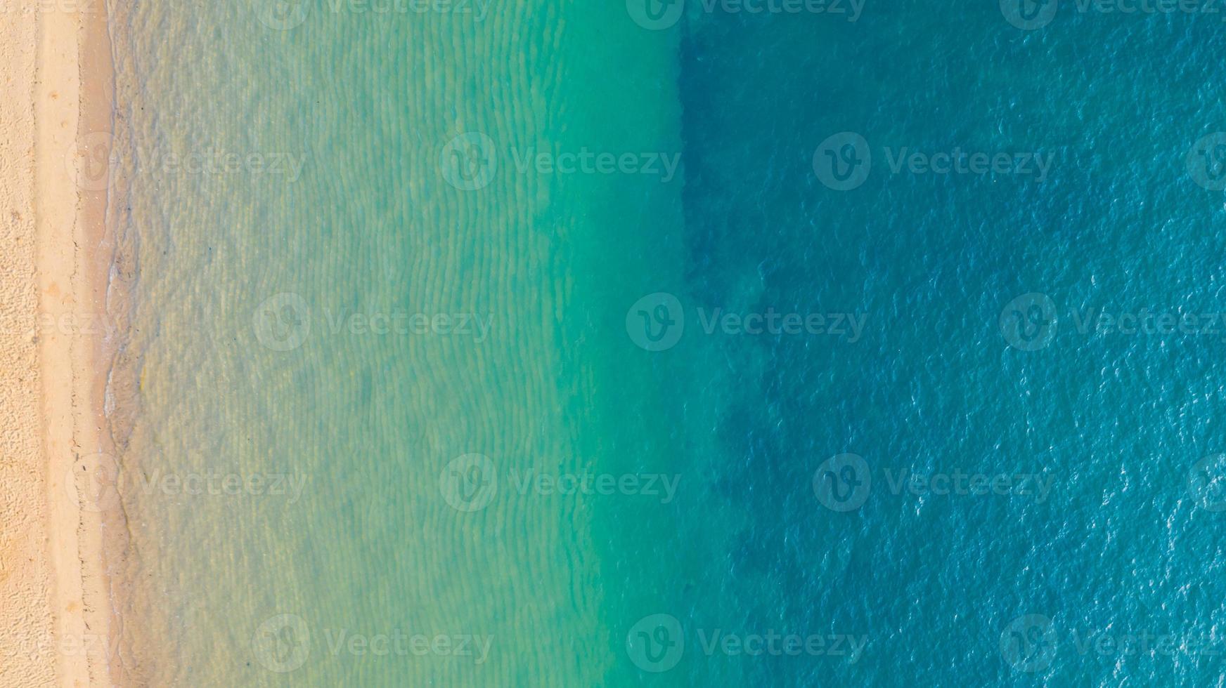 Aerial view of Beach with shade emerald blue water and wave foam on tropical sea photo