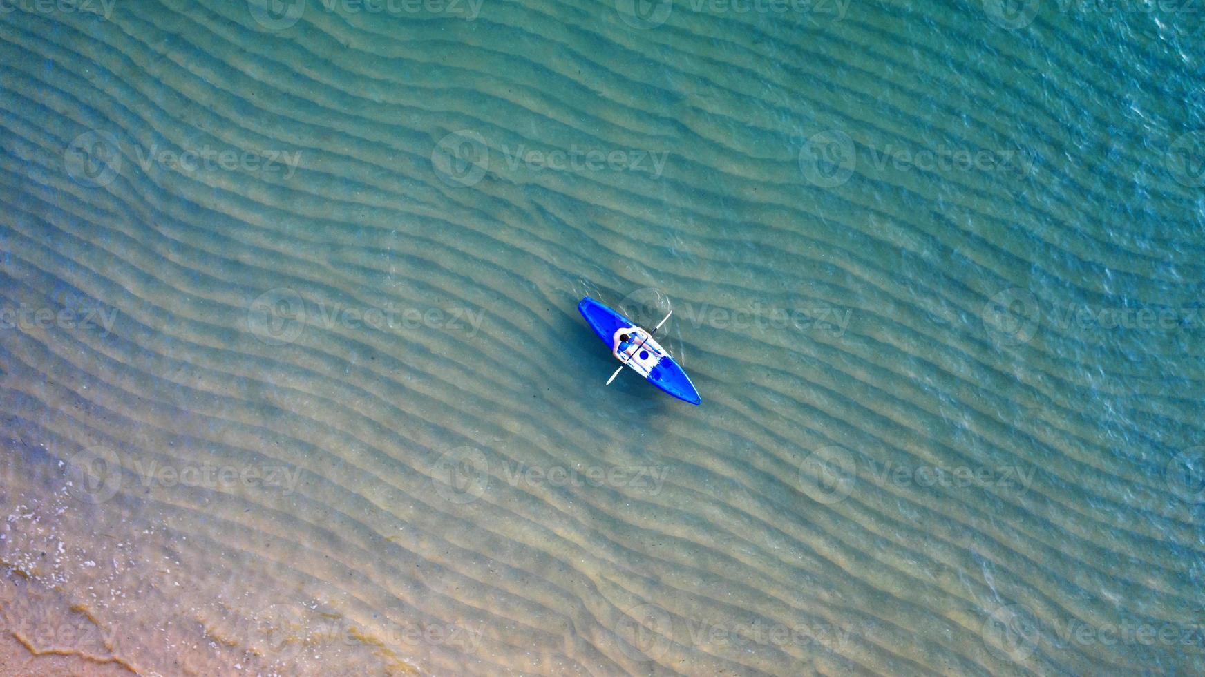 Aerial top view of kayaking around sea with shade emerald blue water and wave foam photo