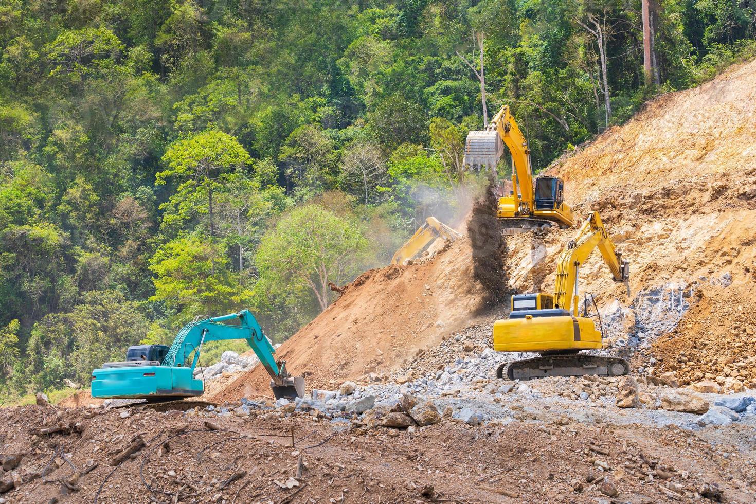 Excavators and stone crushing machine of mining under a blue sky with clouds photo