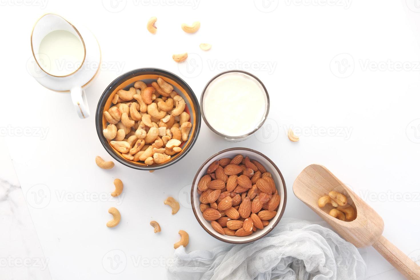 Almond , cashew nut in glass bowl and milk on white background photo