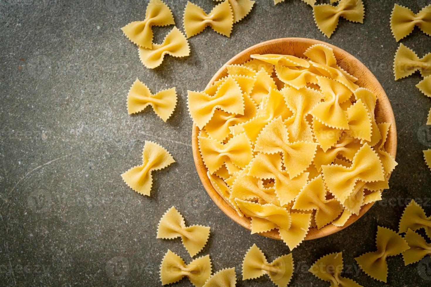 Dry uncooked farfalle pasta in bowl photo