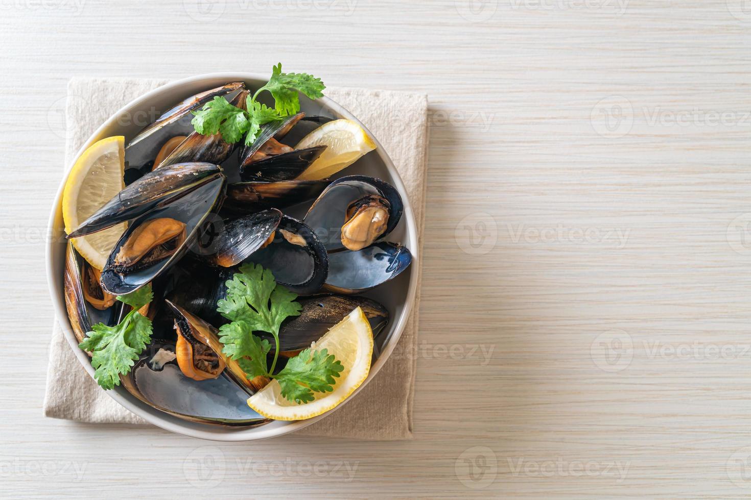 mejillones con hierbas en un bol con limón foto