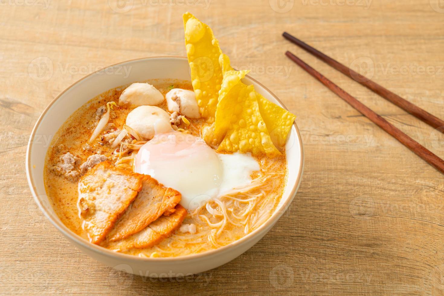 fideos de arroz con albóndigas, cerdo asado y huevo en sopa picante foto