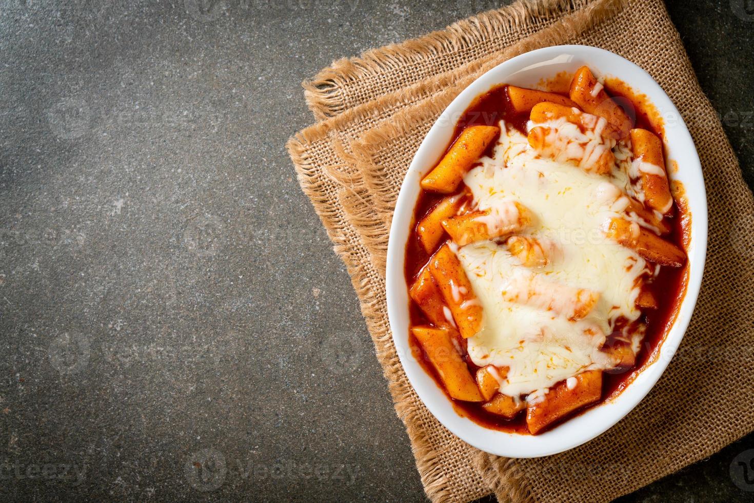 pastel de arroz coreano en salsa coreana picante con queso, tokpokki de queso, tteokbokki con queso foto