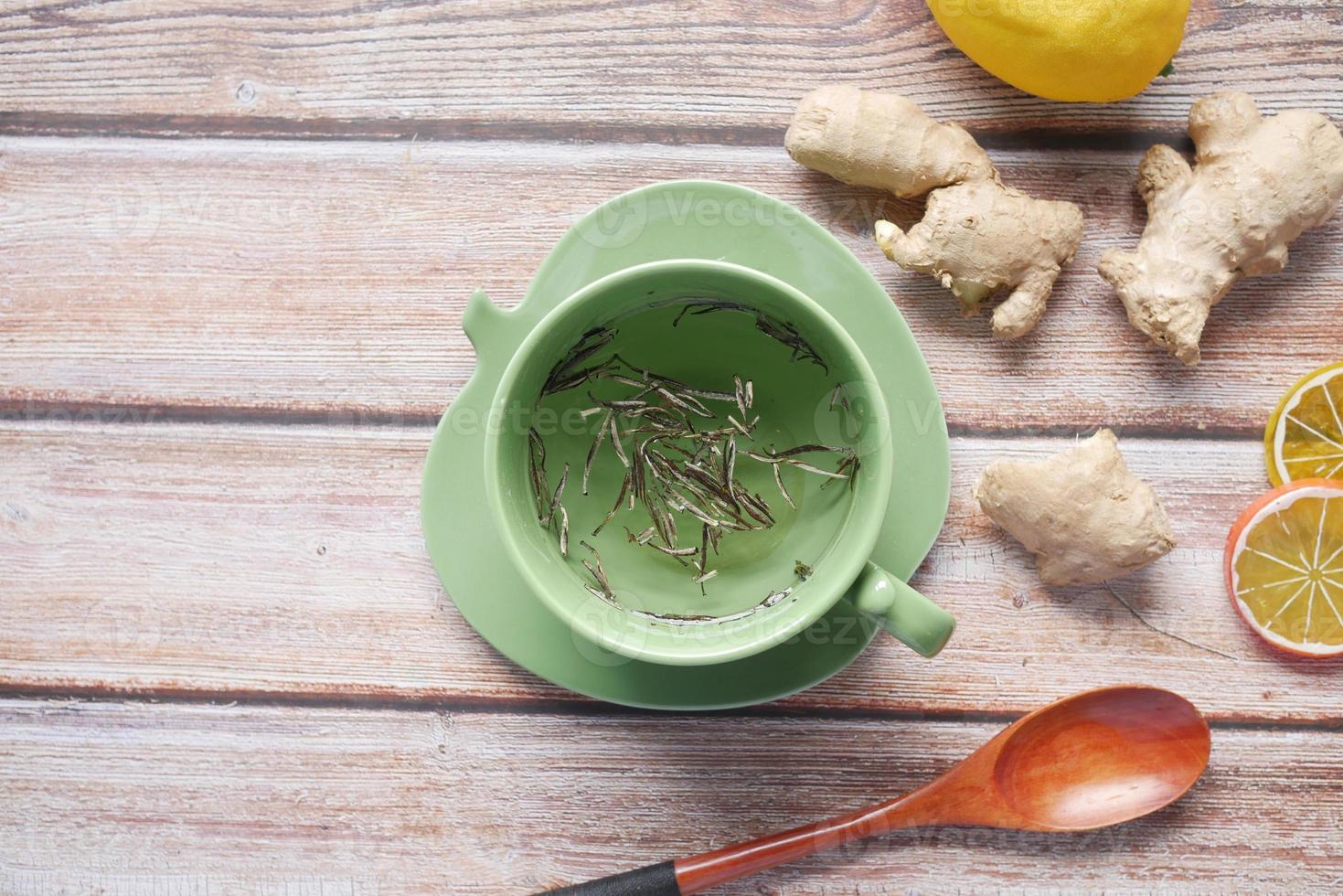 Top view of green tea and herbal leaf in a small glass bowl on table photo