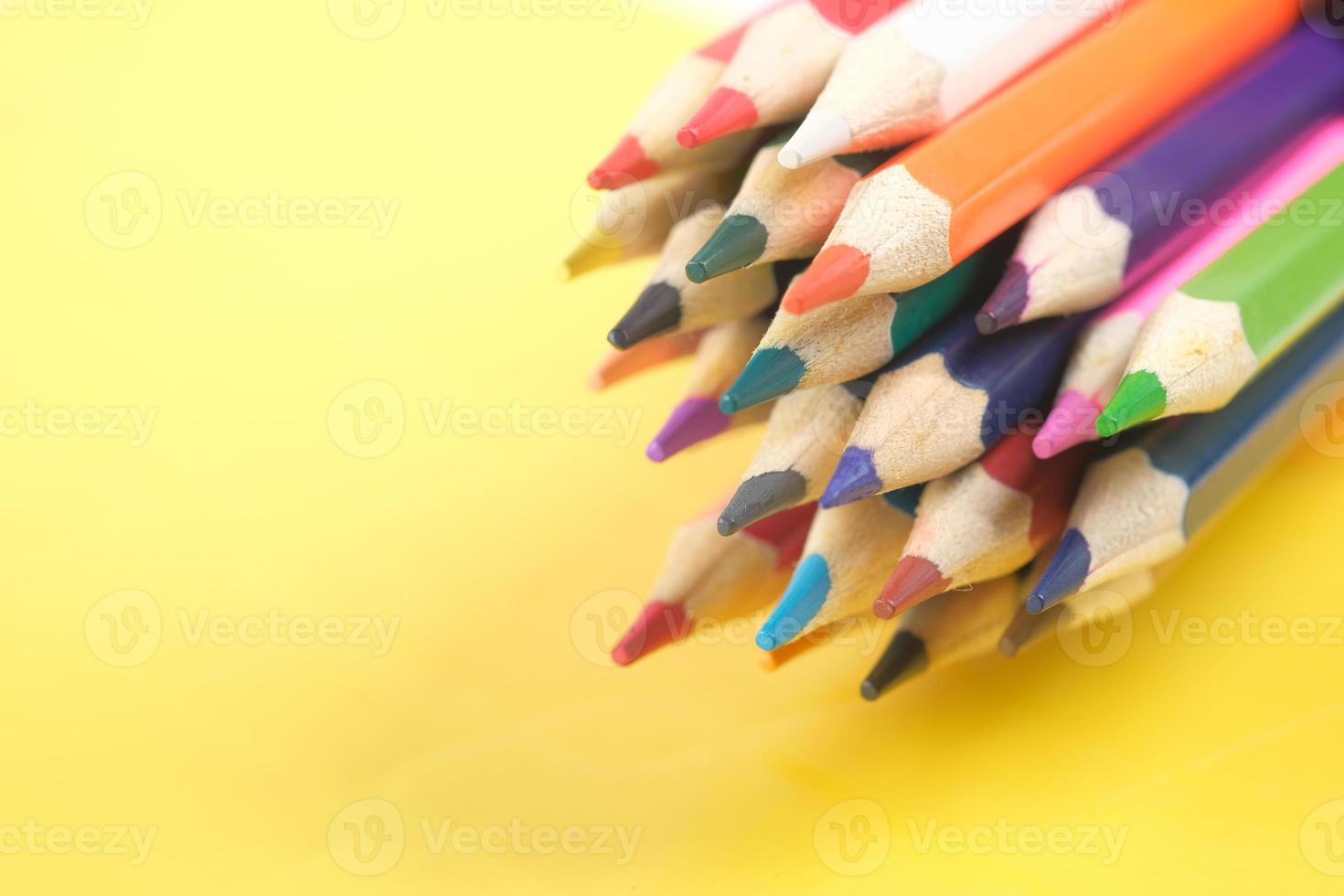 Close up of colorful drawing pencils on yellow photo