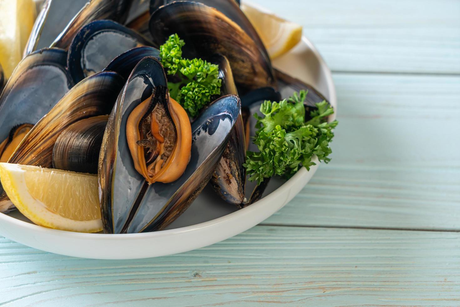 Mussels with herbs in a bowl with lemon photo