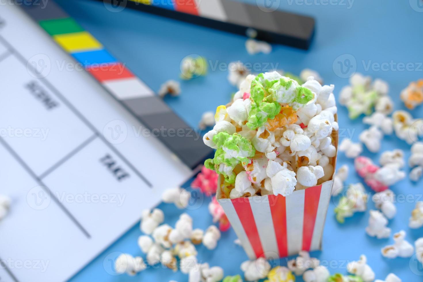 Movie clapper board and popcorn on blue background photo