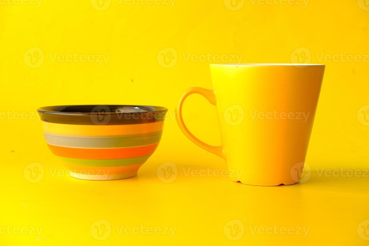 Maqueta de taza de color amarillo con cuadernos sobre fondo amarillo foto