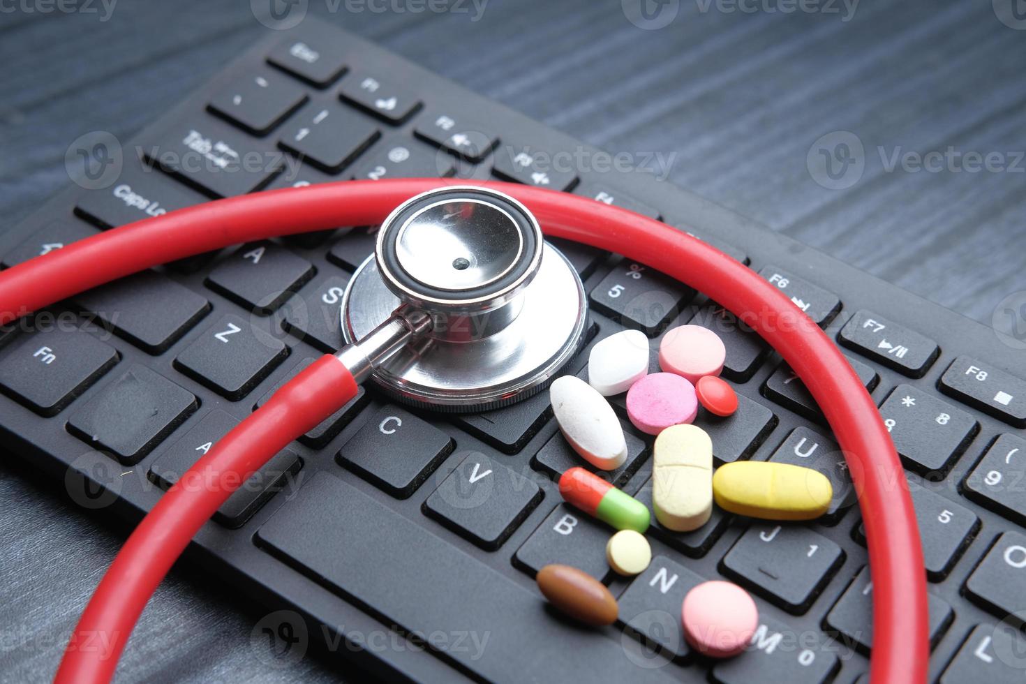 Close up of pills and stethoscope on keyboard photo