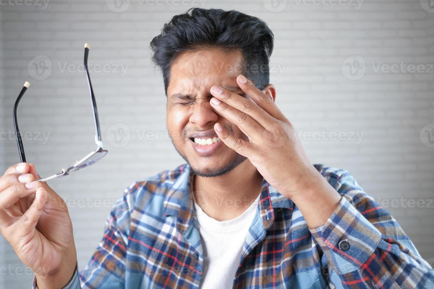 Close up of upset man suffering from strong eye pain photo