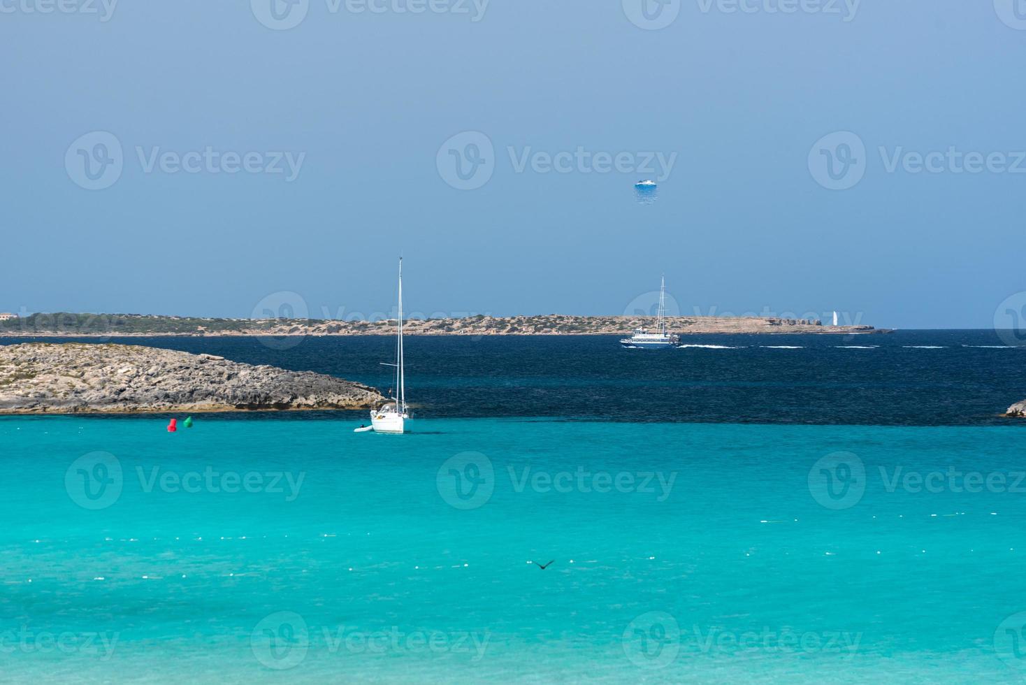 Boats moored on the coast of Ses Illetes beach in Formentera, Balearic Islands in Spain. photo