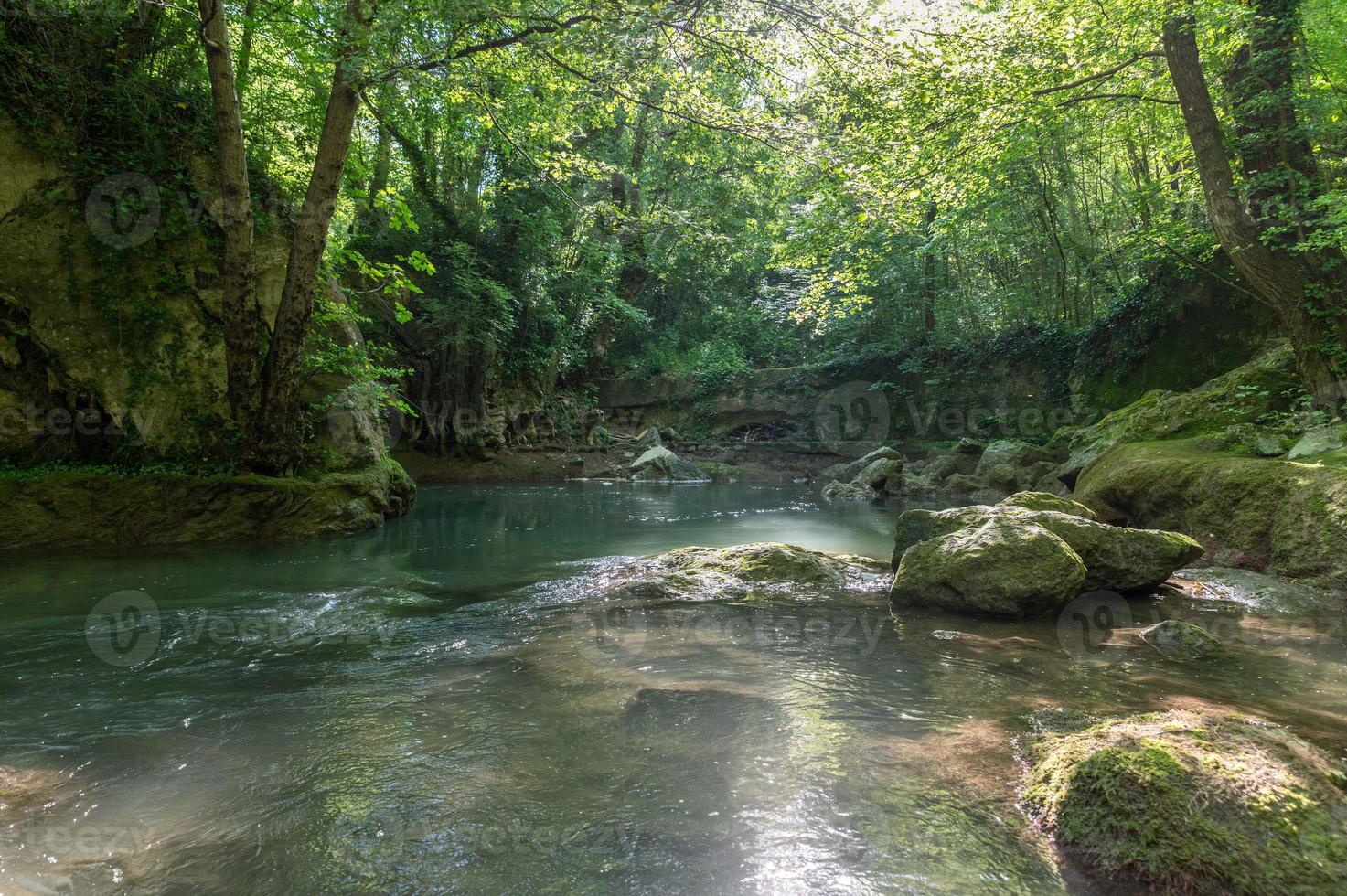 river in the woods coming from the waterfall of the marmore photo