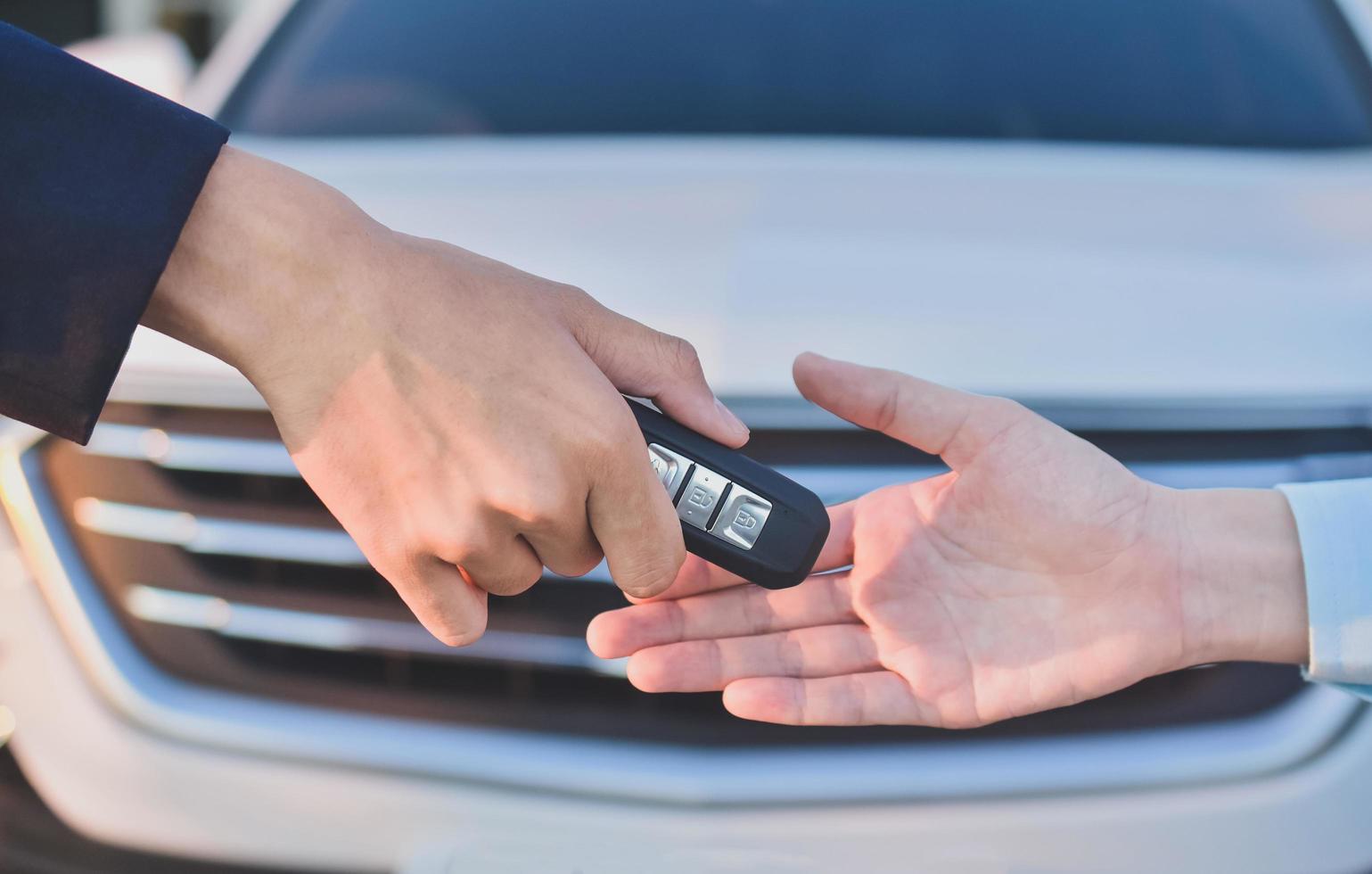 mano dando negocio de coche clave venta alquiler seguro foto