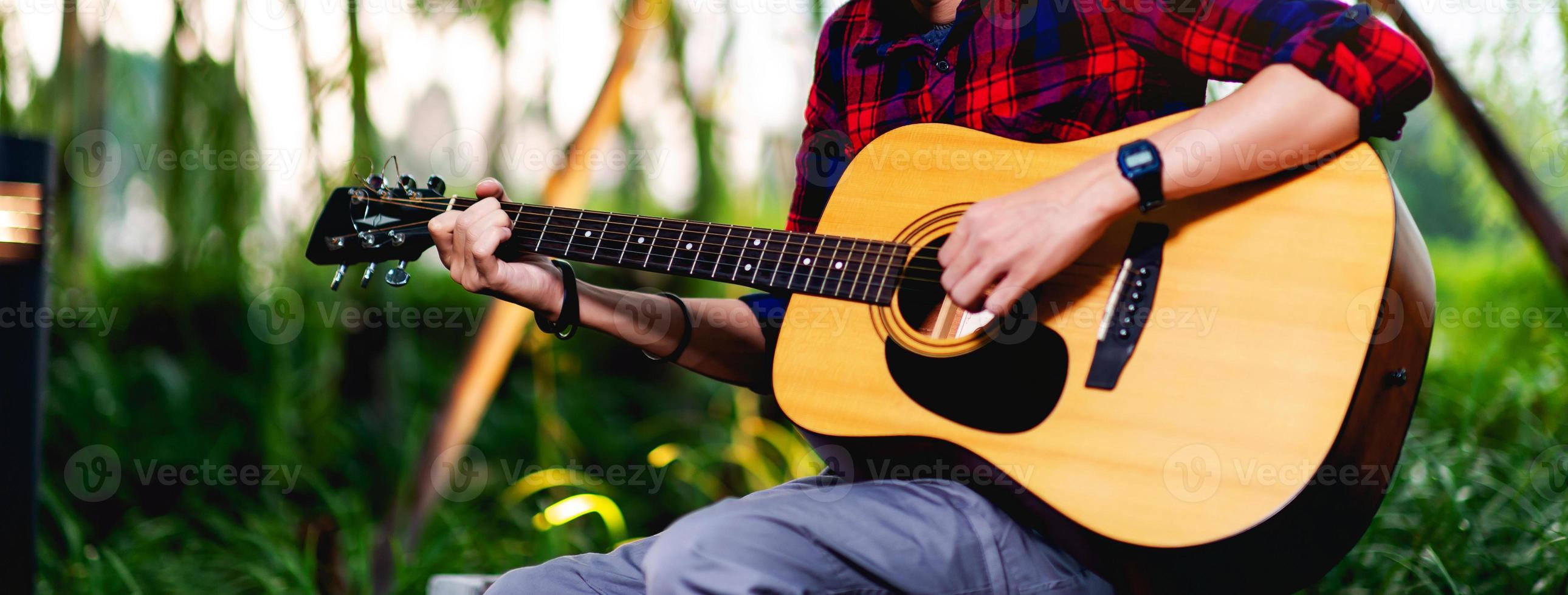 Person playing guitar outside photo