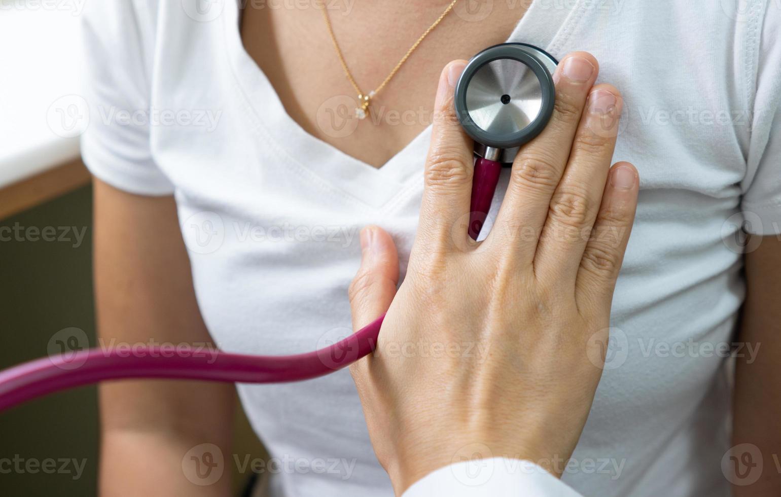 A woman doctor using stethoscope to exam the lung of a pateint that has fever and cough in the clinic in the hospital. medical concept photo