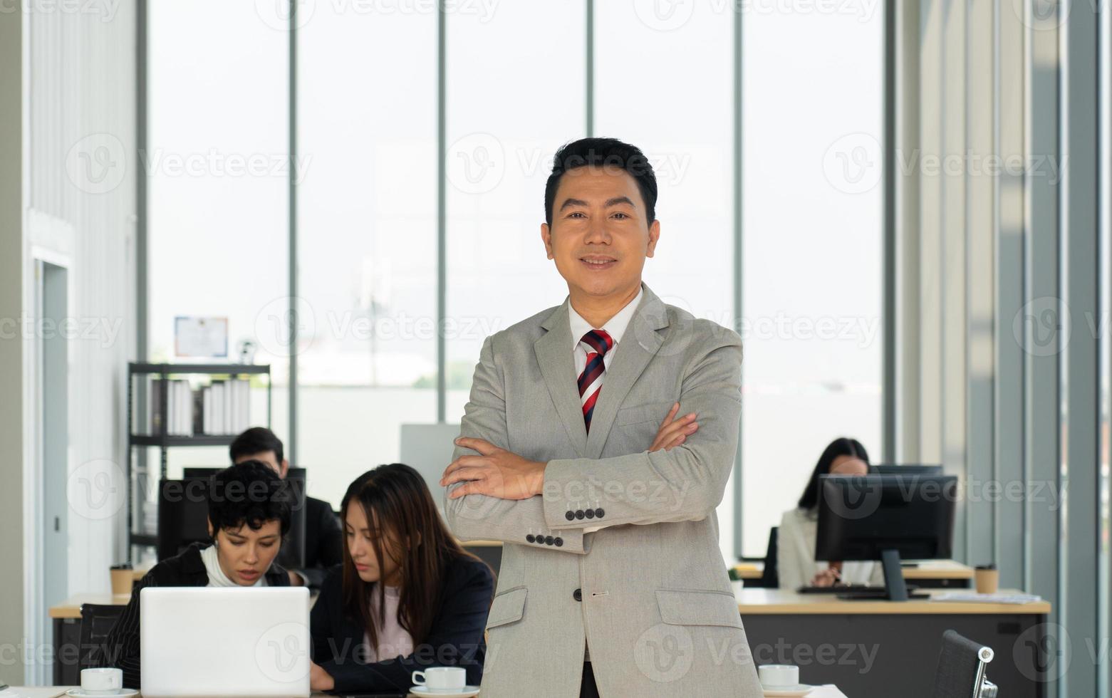 Retrato de hombre de negocios de mediana edad de pie en la oficina foto